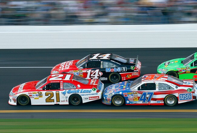DAYTONA BEACH, FL - FEBRUARY 20:  Trevor Bayne, driver of the #21 Motorcraft/Quick Lane Ford, Tony Stewart, driver of the #14 Mobil 1/Office Depot Chevrolet, and Bobby Labonte, driver of the #47 Kroger/USO Toyota, race during the NASCAR Sprint Cup Series Daytona 500 at Daytona International Speedway on February 20, 2011 in Daytona Beach, Florida.  (Photo by Jason Smith/Getty Images for NASCAR)