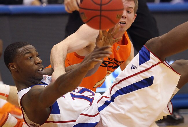 LAWRENCE, KS - FEBRUARY 21:  Elijah Johnson #15 of the Kansas Jayhawks battles Keiton Page #12 of  the Oklahoma State Cowboys for a loose ball during the game on February 21, 2011 at Allen Fieldhouse in Lawrence, Kansas.  (Photo by Jamie Squire/Getty Images)