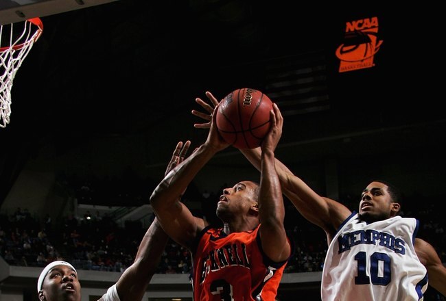 DALLAS, TEXAS - MARCH 19:  Charles Lee #3 of the Bucknell Bison goes up for a shot against Kareem Cooper #42 and Rodney Carney #10 of the Memphis Tigers during the Second Round game of the 2006 NCAA Division 1 Men's Basketball Championship Tournament on March 19, 2006 at the American Airlines Center in Dallas, Texas.  (Photo by Ronald Martinez/Getty Images)