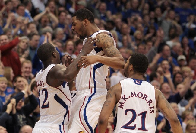 LAWRENCE, KS - DECEMBER 18:  Josh Selby #32 of the Kansas Jayhawks celebrates with Marcus Morris #22 and Markieff Morris #21 after sinking a three-pointer during the final seconds of the game against the USC Trojans on December 18, 2010 at Allen Fieldhouse in Lawrence, Kansas.  The Jayhawks defeated the Trojans with a final score of 70-68.  (Photo by Jamie Squire/Getty Images)