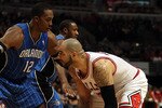 CHICAGO, IL - JANUARY 28: Carlos Boozer #5 of the Chicago Bulls prepares to move against Dwight Howard #12 of the Orlando Magic at the United Center on January 28, 2011 in Chicago, Illinois. The Bulls defeated the Magic 99-90. NOTE TO USER: User expressly acknowledges and agrees that, by downloading and/or using this photograph, User is consenting to the terms and conditions of the Getty Images License Agreement. (Photo by Jonathan Daniel/Getty Images)