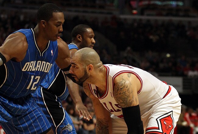 CHICAGO, IL - JANUARY 28: Carlos Boozer #5 of the Chicago Bulls prepares to move against Dwight Howard #12 of the Orlando Magic at the United Center on January 28, 2011 in Chicago, Illinois. The Bulls defeated the Magic 99-90. NOTE TO USER: User expressly acknowledges and agrees that, by downloading and/or using this photograph, User is consenting to the terms and conditions of the Getty Images License Agreement. (Photo by Jonathan Daniel/Getty Images)