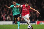 LONDON, ENGLAND - FEBRUARY 16:  Daniel Alves of Barcelona challenges Cesc Fabregas of Arsenal during the UEFA Champions League round of 16 first leg match between Arsenal and Barcelona at the Emirates Stadium on February 16, 2011 in London, England.  (Photo by Shaun Botterill/Getty Images)