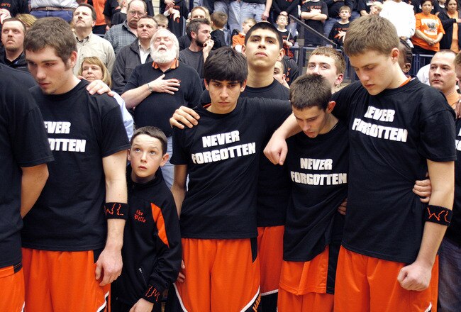 HOLLAND- March 7:  Fennville High School basketball team members stand together for a moment of silence for Wes Leonard before the MHSAA Boys Class C Basketball tournament game against Lawrence High School  March 7, 2011 in Holland, Michigan. Leonard, age 16, a student and star athlete at Fennville High School in Fennville, Michigan, collapsed on a basketball court moments after making the winning shot in overtime to get his team into the Class C District Playoffs. He was pronounced dead shortly afterward at a Holland, Michigan hospital. The cause of death was cardiac arrest due to an enlarged heart. (Photo by Bill Pugliano/Getty Images)