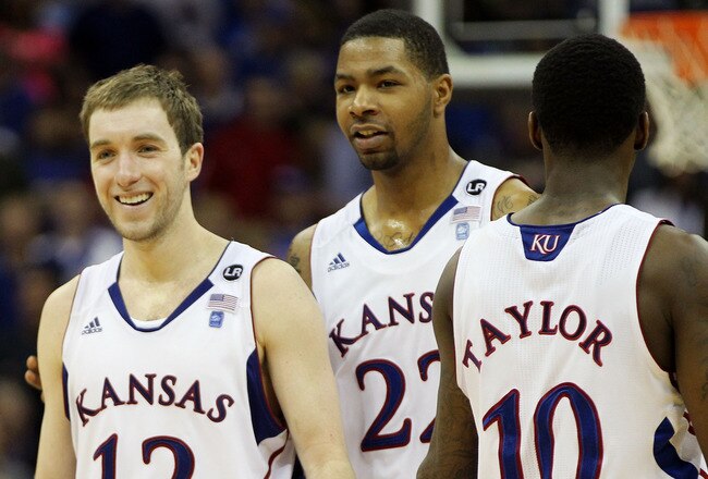 KANSAS CITY, MO - MARCH 12:  Brady Morningstar #12, Marcus Morris #22 and Tyshawn Taylor #10 of the Kansas Jayhawks react after a play against the Texas Longhorns during the 2011 Phillips 66 Big 12 Men's Basketball Tournament championship game at Sprint Center on March 12, 2011 in Kansas City, Missouri.  (Photo by Jamie Squire/Getty Images)