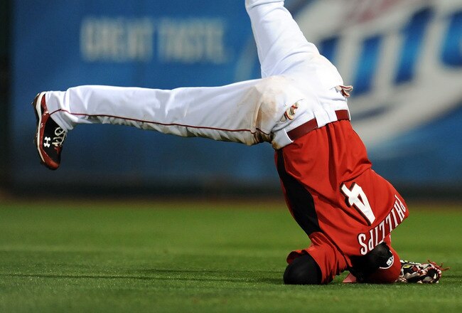 GOODYEAR, AZ - MARCH 03:  Brandon Phillips #4 of the Cincinnati Reds ends up on his head while catching a pop fly against the Los Angeles Dodgers at Goodyear Ballpark on March 3, 2011 in Goodyear, Arizona.  (Photo by Norm Hall/Getty Images)
