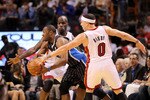 MIAMI, FL - MARCH 03:  Gilbert Arenas #1 of the Orlando Magic passes around Mike Bibby #0 and Joel Anthony #50 of the Miami Heat during a game at American Airlines Arena on March 3, 2011 in Miami, Florida. NOTE TO USER: User expressly acknowledges and agrees that, by downloading and/or using this Photograph, User is consenting to the terms and conditions of the Getty Images License Agreement.  (Photo by Mike Ehrmann/Getty Images)
