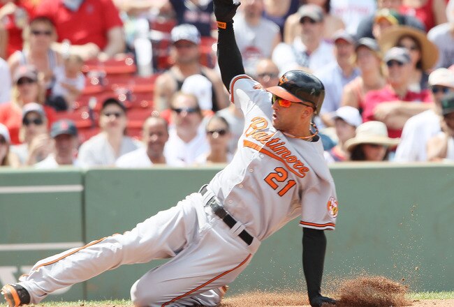 BOSTON - JULY 04:  Nick Markakis #21 of the Baltimore Orioles scores a run on a wild pitch in the fourth inning against the Boston Red Sox on July 4, 2010 at Fenway Park in Boston, Massachusetts.  (Photo by Elsa/Getty Images)