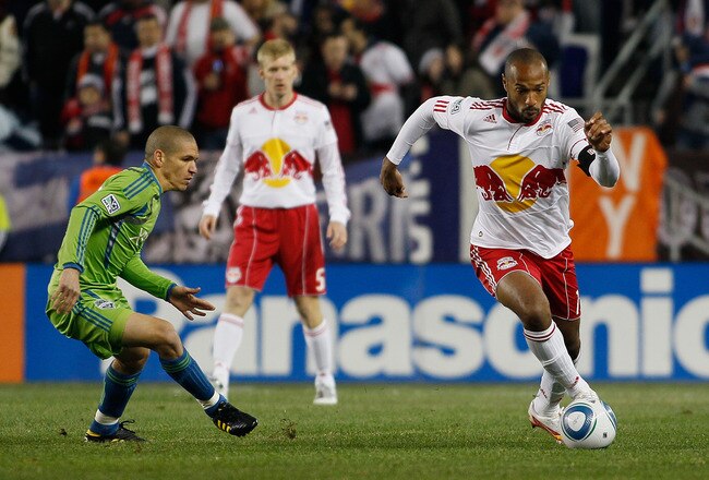 HARRISON, NJ - MARCH 19:  Thierry Henry #14 of the New York Red Bulls carries the ball against Osvaldo Alonso #6 of the Seattle Sounders FC on March 19, 2011 at Red Bull Arena in Harrison, New Jersey.  (Photo by Mike Stobe/Getty Images for New York Red Bulls)