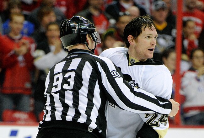 WASHINGTON, DC - FEBRUARY 06:  Matt Cooke #24 of the Pittsburgh Penguins is led to the penalty box by Brian Murphy #93 during the game against the Washington Capitals at the Verizon Center on February 6, 2011 in Washington, DC.  (Photo by Greg Fiume/Getty Images)