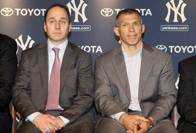 NEW YORK, NY - JANUARY 19:  General manager Brian Cashman (L) and manager Joe Girardi of the New York Yankees listen as Rafael Soriano (not pictured) speaks during his introduction press conference on January 19, 2011 at Yankee Stadium in the Bronx borough of New York City. The Yankees signed Soriano to a three-year contract.  (Photo by Jim McIsaac/Getty Images)