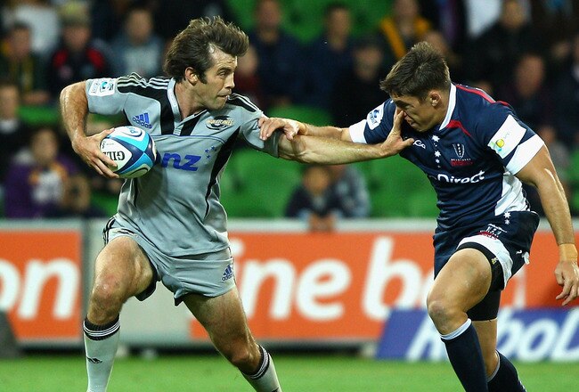MELBOURNE, AUSTRALIA - MARCH 25:  Conrad Smith of the Hurricanes fends off JP du Plessis of the Rebels during the round six Super Rugby match between the Melbourne Rebels and the Hurricanes on March 25, 2011 in Melbourne, Australia.  (Photo by Mark Dadswell/Getty Images)