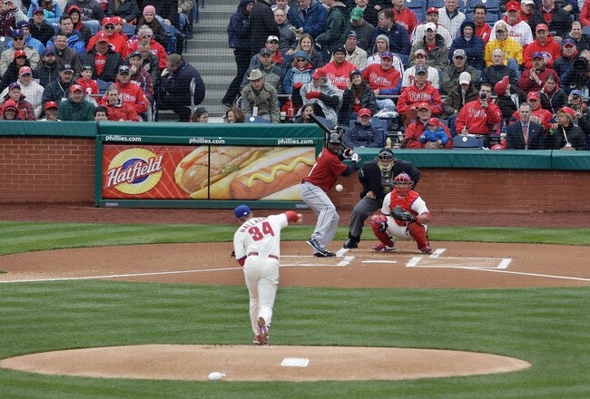 PHILADELPHIA, PA - APRIL 01:  Starting pitcher Roy Halladay #34 of the Philadelphia Phillies delivers the first pitch of opening day to batter Michael Bourn #21 of the Houston Astros as catcher Carlos Ruiz #51 of the Philadelphia Phillies and home plate umpire  Jerry Layne wait for the pitch at Citizens Bank Park on April 1, 2011 in Philadelphia, Pennsylvania.