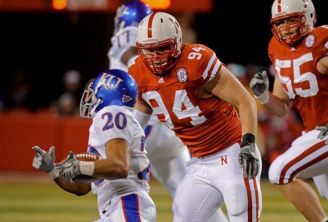 LINCOLN, NE - NOVEMBER 13: Jared Crick #94 and Baker Steinkuhler #55 of the Nebraska Cornhuskers run down D.J. Beshears #20 of the Kansas Jayhawks during first half action of their game at Memorial Stadium on November 13, 2010 in Lincoln, Nebraska.  (Photo by Eric Francis/Getty Images)
