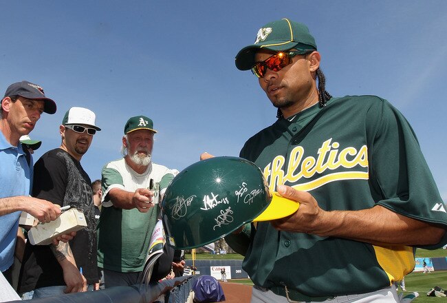 PHOENIX, AZ - MARCH 03:  Outfielder Coco Crisp #4 of the Oakland Athletics signs autographs for fans before the spring training game against the Milwaukee Brewers at Maryvale Baseball Park on March 3, 2011 in Phoenix, Arizona.  (Photo by Christian Petersen/Getty Images)