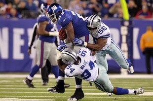 EAST RUTHERFORD, NJ - NOVEMBER 14: Bradie James #56 and DeMarcus Ware #94 of the Dallas Cowboys combine to stop a run by Brandon Jacobs #27 of the New York Giants on November 14, 2010 at the New Meadowlands Stadium in East Rutherford, New Jersey. The Cowboys defeated the Giants 33-20.  (Photo by Jim McIsaac/Getty Images)