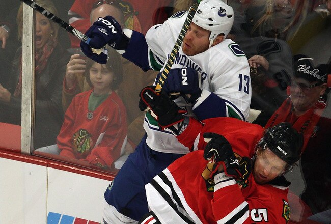 CHICAGO, IL - APRIL 17: Raffi Torres #13 of the Vancouver Canucks gets called for a roughing penalty with this hit on Brian Campbell #51 of the Chicago Blackhawks in Game Three of the Western Conference Quarterfinals during the 2011 NHL Stanley Cup Playoffs at the United Center on April 17, 2011 in Chicago, Illinois. (Photo by Jonathan Daniel/Getty Images)