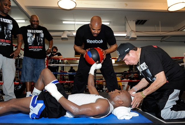 LAS VEGAS - APRIL 14: Boxer Floyd Mayweather Jr. works out with help from (L-R) camp coordinator DeJuan Blake, massage therapist John Sinclair, Mayweather Promotions CEO Leonard Ellerbe and cornerman Rafael Garcia April 14, 2010 in Las Vegas, Nevada. Mayweather is scheduled to face Shane Mosley in a 12-round welterweight bout on May 1, 2010 in Las Vegas. (Photo by Ethan Miller/Getty Images)