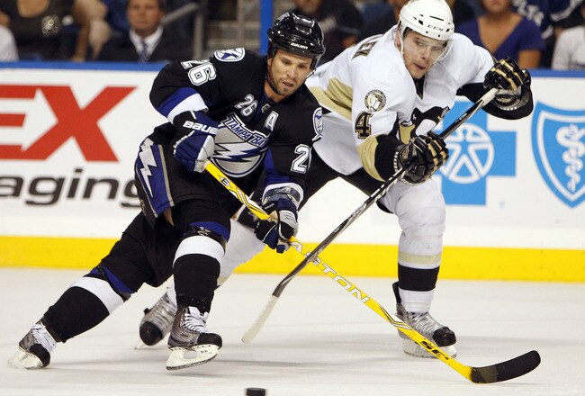 TAMPA, FL - APRIL 20: Martin St. Louis #26 of the Tampa Bay Lightning crosses sticks with Zbynek Michalek #4 of the Pittsburgh Penguins in the first overtime period in Game Four of the Eastern Conference Quarterfinals during the 2011 NHL Stanley Cup Playoffs at the St. Pete Times Forum on April 20, 2011 in Tampa, Florida. (Photo by Eliot J. Schechter/Getty Images)