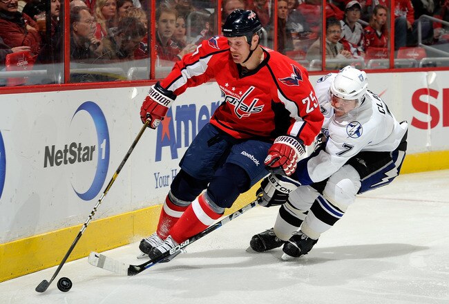 WASHINGTON - NOVEMBER 26:  Brett Clark #7 of the Tampa Bay Lightning battles for the puck against Jason Chimera #25 of the Washington Capitals at the Verizon Center on November 26, 2010 in Washington, DC.  (Photo by Greg Fiume/Getty Images)