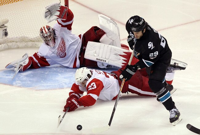 SAN JOSE, CA - APRIL 29:  Brad Stuart #23 and Jimmy Howard #35 of the Detroit Red Wings dive to stop a shot by Ryane Clowe #29 of the San Jose Sharks in Game One of the Western Conference Semifinals during the 2011 NHL Stanley Cup Playoffs at HP Pavilion on April 29, 2011 in San Jose, California.  (Photo by Ezra Shaw/Getty Images)