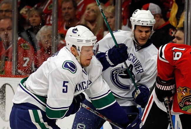 CHICAGO - MAY 09: Jonathan Toews #19 of the Chicago Blackhawks controls the puck under pressure from Christian Ehrhoff #5 and Kevin Bieksa #3 of the Vancouver Canucks in Game Five of the Western Conference Semifinals during the 2010 NHL Stanley Cup Playoffs at United Center on May 9, 2010 in Chicago, Illinois. (Photo by Jonathan Daniel/Getty Images)