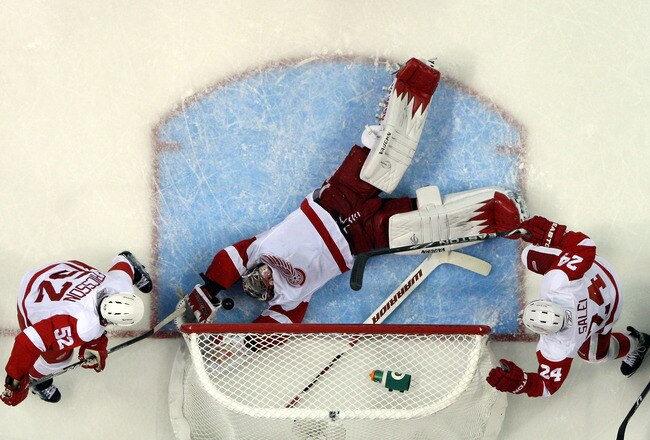 SAN JOSE, CA - MAY 01:  Jimmy Howard #35 of the Detroit Red Wings makes a diving save during the second period of their game against the San Jose Sharks in Game Two of the Western Conference Semifinals during the 2011 NHL Stanley Cup Playoffs at HP Pavilion on May 1, 2011 in San Jose, California. Howard's teammates Jonathan Ericsson #52 and Ruslan Salei #24 watch their goalie make the save.  (Photo by Ezra Shaw/Getty Images)