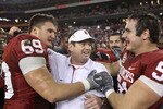 GLENDALE, AZ - JANUARY 01:  Head coach Bob Stoops is hugged by Eric Mensik #69 and Brian Lepak #51 late in the fourth quarter before the Sooners 48-20 victory against the Connecticut Huskies during the Tostitos Fiesta Bowl at the Universtity of Phoenix Stadium on January 1, 2011 in Glendale, Arizona.  (Photo by Christian Petersen/Getty Images)