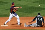 GOODYEAR, AZ - MARCH 11:  Cord Phelps #73 of the Cleveland Indians turns a double play over the top of a sliding Carlos Peguero #64 of the Seattle Mariners at Goodyear Ballpark on March 11, 2011 in Goodyear, Arizona.  (Photo by Norm Hall/Getty Images)