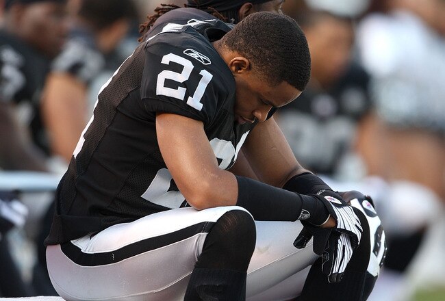 OAKLAND, CA - JANUARY 3:  Nnamdi Asomugha #21 of the Oakland Raiders sits on the bench against the Baltimore Ravens during an NFL game at Oakland-Alameda County Coliseum on January 3, 2010 in Oakland, California. (Photo by Jed Jacobsohn/Getty Images)
