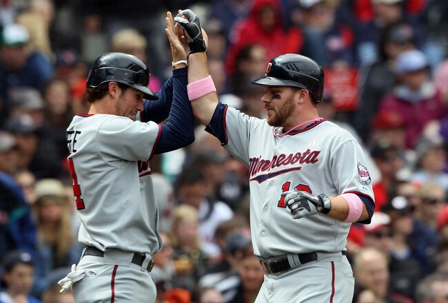BOSTON, MA - MAY 08: Trevor Plouffe #24 and Jason Kubel #16 of the Minnesota Twins celebrate after they scored off a single by Danny Valencia in the first inning against the Boston Red Sox  on May 8, 2011 at Fenway Park in Boston, Massachusetts.  (Photo by Elsa/Getty Images)