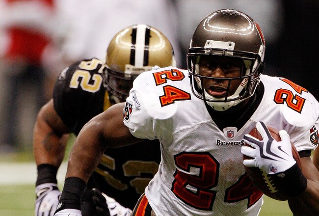 NEW ORLEANS - DECEMBER 27:  Cadillac Williams #24 of the Tampa Bay Buccaneers runs past Jonathan Casillas #52  of the New Orleans Saints at the Louisiana Superdome on December 27, 2009 in New Orleans, Louisiana.  (Photo by Chris Graythen/Getty Images)