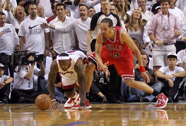 MIAMI, FL - MAY 24:  LeBron James #6 of the Miami Heat reaches for a loose ball against Joakim Noah #13 of the Chicago Bulls in Game Four of the Eastern Conference Finals during the 2011 NBA Playoffs on May 24, 2011 at American Airlines Arena in Miami, Florida. The Heat won 101-93 in overtime. NOTE TO USER: User expressly acknowledges and agrees that, by downloading and or using this photograph, User is consenting to the terms and conditions of the Getty Images License Agreement.  (Photo by Mike Ehrmann/Getty Images)