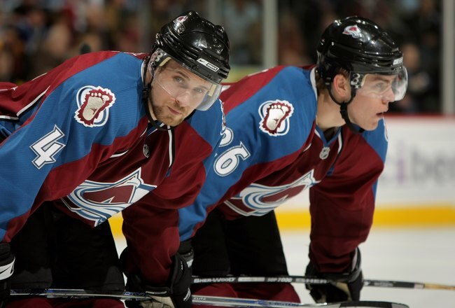 DENVER - MARCH 04:  John-Michael Liles #4 and Paul Stastny #26 of the Colorado Avalanche await a face off against the Vancouver Canucks at the Pepsi Center on March 4, 2008 in Denver, Colorado. The Avalanche defeated the Canucks 2-1.  (Photo by Doug Pensinger/Getty Images)