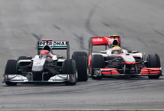 SHANGHAI, CHINA - APRIL 18:  Michael Schumacher (red helmet) of Germany and Mercedes GP and Lewis Hamilton (yellow helmet) of Great Britain and McLaren Mercedes fight for position as they drive during the Chinese Formula One Grand Prix at the Shanghai International Circuit on April 18, 2010 in Shanghai, China.  (Photo by Mark Thompson/Getty Images)