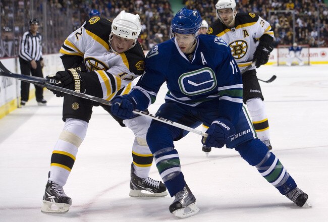 VANCOUVER, CANADA - FEBRUARY 26: Ryan Kesler #17 of the Vancouver Canucks battles with Tomas Kaberle #12 of the Boston Bruins while in the corner during the second period in NHL action on February 26, 2011 at Rogers Arena in Vancouver, British Columbia, Canada.  (Photo by Rich Lam/Getty Images)