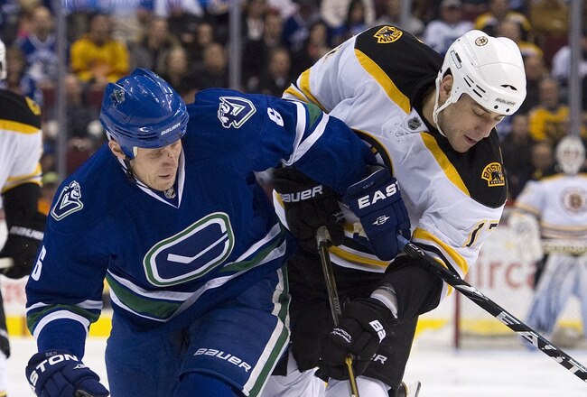 VANCOUVER, CANADA - FEBRUARY 26: Sami Salo #6 of the Vancouver Canucks ties up Milan Lucic #17 of the Boston Bruins during the first period in NHL action on February 26, 2011 at Rogers Arena in Vancouver, British Columbia, Canada.  (Photo by Rich Lam/Getty Images)