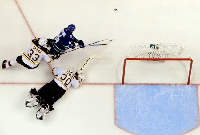 VANCOUVER, BC - JUNE 04:  Alex Burrows #14 of the Vancouver Canucks gets chased by Zdeno Chara #33 of the Boston Bruins as goalie Tim Thomas #30 falls to the ice during overtime in Game Two of the 2011 NHL Stanley Cup Final at Rogers Arena on June 4, 2011 in Vancouver, British Columbia, Canada.  (Photo by Bruce Bennett/Getty Images)