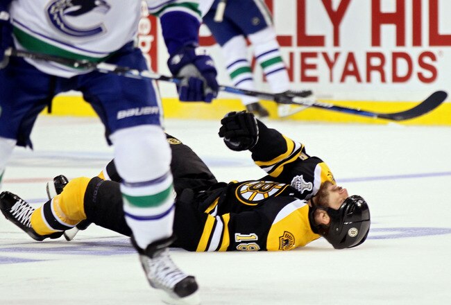 BOSTON, MA - JUNE 06:  Nathan Horton #18 of the Boston Bruins falls to the ice after being check by Aaron Rome #29 of the Vancouver Canucks during Game Three of the 2011 NHL Stanley Cup Final at TD Garden on June 6, 2011 in Boston, Massachusetts.  (Photo by Elsa/Getty Images)