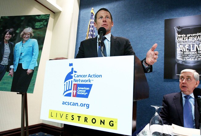 WASHINGTON, DC - MARCH 24:  LIVESTRONG Founder and Chairman and seven-time Tour de France champion Lance Armstrong (L) speaks as American Cancer Society Cancer Action Network Chief Executive John Seffrin (R) listens during a news conference at the National Press Club March 24, 2011 in Washington, DC. American Cancer Society Cancer Action Network held a news conference to call on the Congress to oppose proposed cuts to cancer research and prevention programs.  (Photo by Alex Wong/Getty Images)