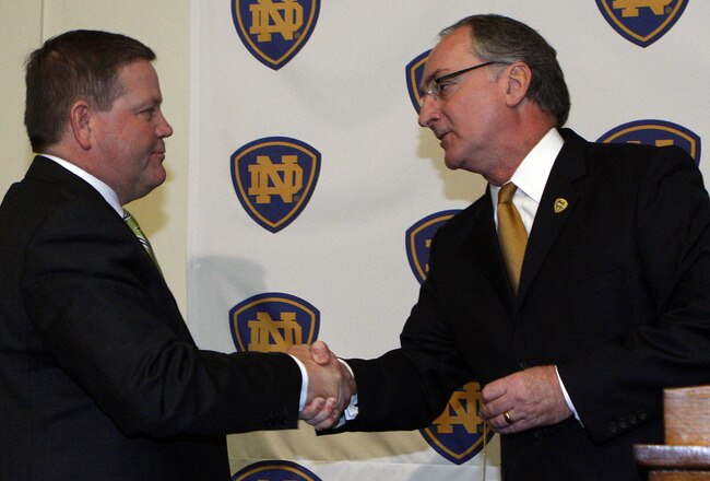 SOUTH BEND, IN - DECEMBER 11: Notre Dame atheletic director Jack Swarbrick (R) greets Brian Kelly as he is introduced as the new football head coach at Notre Dame University on December 11, 2009 in South Bend, Indiana.  Kelly most recently led the University of Cincinnati to two consecutive Bowl Championship Series appearances including a perfect 12-0 record this past season. (Photo by Frank Polich/Getty Images)