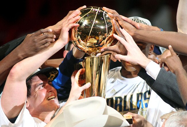 MIAMI, FL - JUNE 12:  Team owner Mark Cuban of the Dallas Mavericks celebrates with the Larry O'Brien trophy after the Mavericks won 105-95 against the Miami Heat in Game Six of the 2011 NBA Finals at American Airlines Arena on June 12, 2011 in Miami, Florida. NOTE TO USER: User expressly acknowledges and agrees that, by downloading and/or using this Photograph, user is consenting to the terms and conditions of the Getty Images License Agreement.  (Photo by Marc Serota/Getty Images)