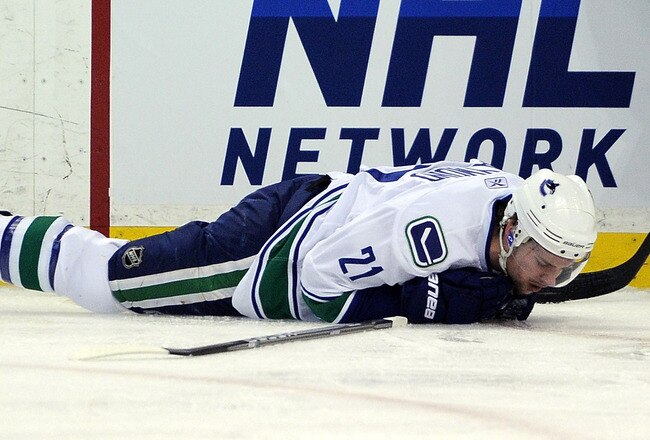 BOSTON, MA - JUNE 13:  Mason Raymond #21 of the Vancouver Canucks lays on the ice after being checked by Johnny Boychuk #55 of the Boston Bruins during Game Six of the 2011 NHL Stanley Cup Final at TD Garden on June 13, 2011 in Boston, Massachusetts.  (Photo by Harry How/Getty Images)