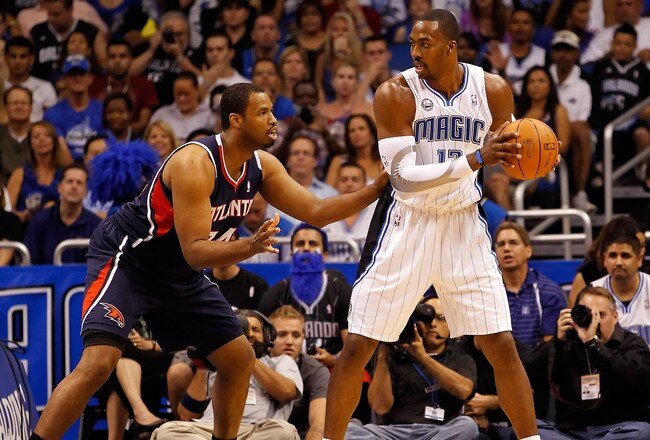 ORLANDO, FL - APRIL 26:  Jason Collins #34 of the Atlanta Hawks guards Dwight Howard #12 of the Orlando Magic during Game Five of the Eastern Conference Quarterfinals of the 2011 NBA Playoffs on April 26, 2011 at the Amway Arena in Orlando, Florida.  NOTE TO USER: User expressly acknowledges and agrees that, by downloading and/or using this Photograph, user is consenting to the terms and conditions of the Getty Images License Agreement.  (Photo by J. Meric/Getty Images)