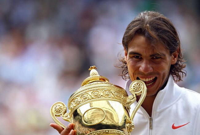 LONDON, ENGLAND - JULY 04:  Rafael Nadal of Spain bites the Championship trophy after winning the Men's Singles Final match against Tomas Berdych of Czech Republic on Day Thirteen of the Wimbledon Lawn Tennis Championships at the All England Lawn Tennis and Croquet Club on July 4, 2010 in London, England.  (Photo by Julian Finney/Getty Images)
