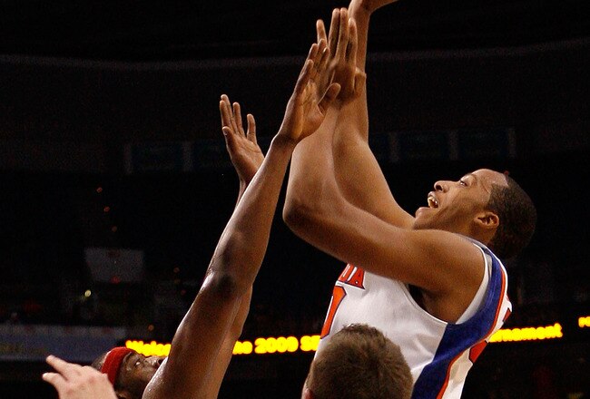 TAMPA, FL - MARCH 12:  Kenny Kadji #30 of the Florida Gators makes a shot over Michael Washington #00 and Rotnei Clarke #15 of the Arkansas Razorbacks  during the first round of the SEC Men's Basketball Tournament on March 12, 2009 at The St. Pete Times Forum in Tampa, Florida.  (Photo by Chris Graythen/Getty Images)