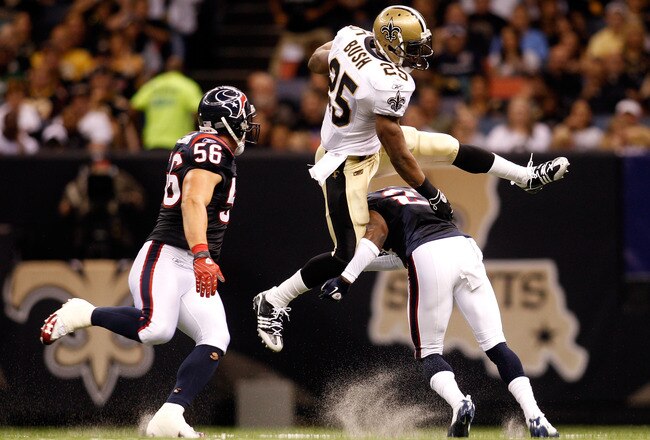 NEW ORLEANS - AUGUST 21:  Reggie Bush #25 of the New Orleans Saints jumps over Brice McCain #21 of the Houston Texans at the Louisiana Superdome on August 21, 2010 in New Orleans, Louisiana.  (Photo by Chris Graythen/Getty Images)