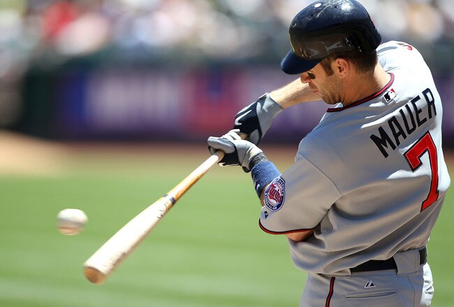 OAKLAND, CA - JUNE 6:  Joe Mauer #7 of the Minnesota Twins makes contact with the ball against the Oakland Athletics during an MLB game at the Oakland-Alameda County Coliseum on June 6, 2010 in Oakland, California. (Photo by Jed Jacobsohn/Getty Images)