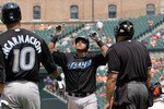 BALTIMORE, MD - JUNE 05:  Yunel Escobar #5 (C) of the Toronto Blue Jays celebrates his three RBI home run against the Baltimore Orioles as teammate Edwin Encarnacion #10 and homeplate umpire Kevin Danley (R) look on during the fourth inning at Oriole Park at Camden Yards on June 5, 2011 in Baltimore, Maryland.  (Photo by Rob Carr/Getty Images)