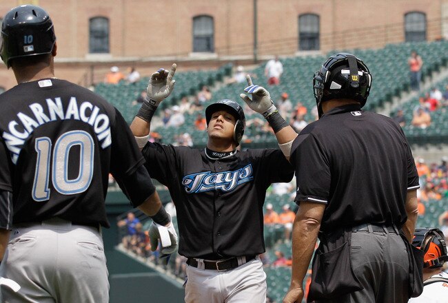 BALTIMORE, MD - JUNE 05:  Yunel Escobar #5 (C) of the Toronto Blue Jays celebrates his three RBI home run against the Baltimore Orioles as teammate Edwin Encarnacion #10 and homeplate umpire Kevin Danley (R) look on during the fourth inning at Oriole Park at Camden Yards on June 5, 2011 in Baltimore, Maryland.  (Photo by Rob Carr/Getty Images)